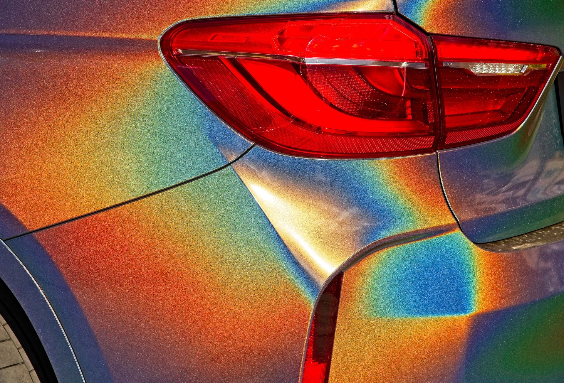 Detail of rear corner and light of car with shiny color shifting paint.